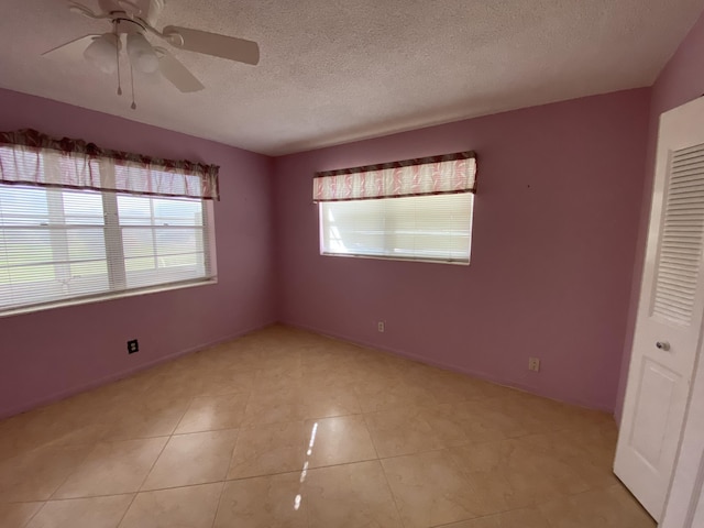 unfurnished bedroom with ceiling fan, light tile patterned floors, a textured ceiling, and a closet