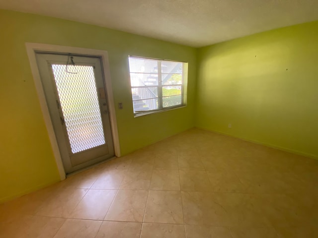 doorway to outside with light tile patterned flooring