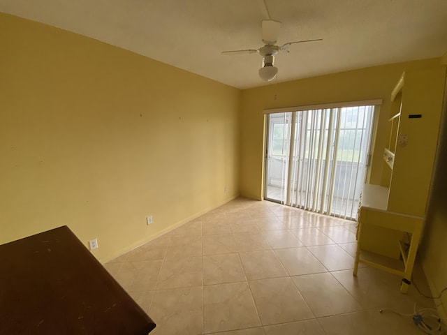 tiled spare room featuring ceiling fan