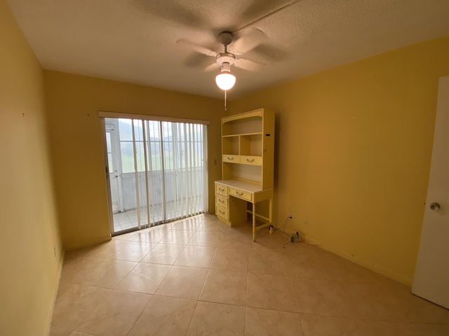 unfurnished room with a textured ceiling, ceiling fan, and light tile patterned flooring