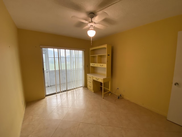 95 Cambridge E Unit 95, West Palm Beach, FL 33417 - spare room featuring a ceiling fan, light tile patterned floors, baseboards, and a textured ceiling
