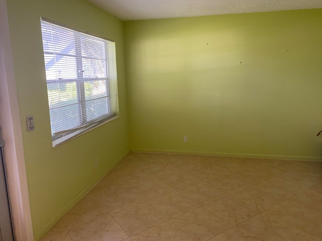 unfurnished room with a textured ceiling