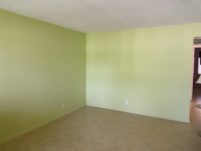 95 Cambridge E Unit 95, West Palm Beach, FL 33417 - spare room with a textured ceiling and baseboards