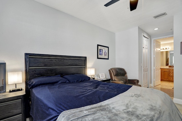 bedroom with light tile patterned floors, ensuite bath, and ceiling fan