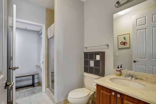 bathroom featuring tile patterned floors, a shower with door, vanity, and toilet