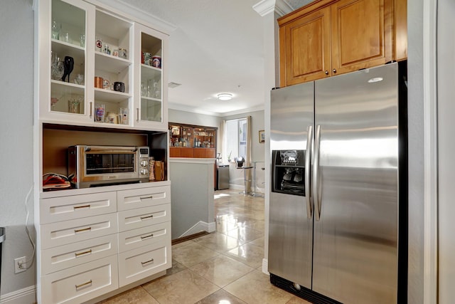 kitchen featuring light tile patterned floors, stainless steel refrigerator with ice dispenser, and ornamental molding