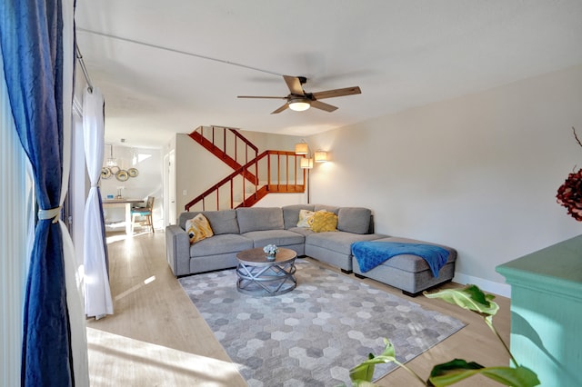 living room featuring wood-type flooring and ceiling fan with notable chandelier