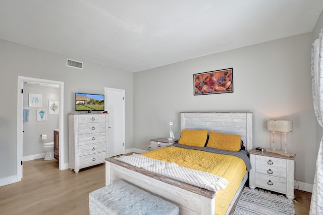 bedroom with ensuite bathroom and light wood-type flooring