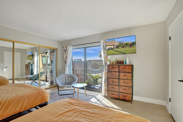 bedroom with access to exterior and light hardwood / wood-style flooring