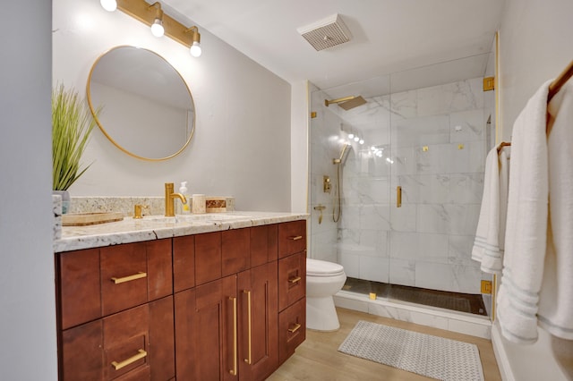 bathroom with walk in shower, hardwood / wood-style floors, vanity, and toilet