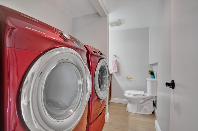 washroom with washer and dryer and light hardwood / wood-style floors