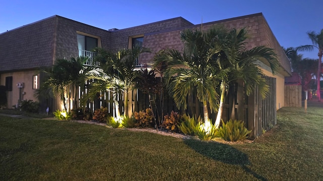 property exterior at dusk with a lawn