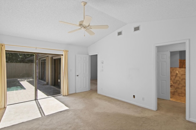 carpeted spare room featuring ceiling fan and lofted ceiling