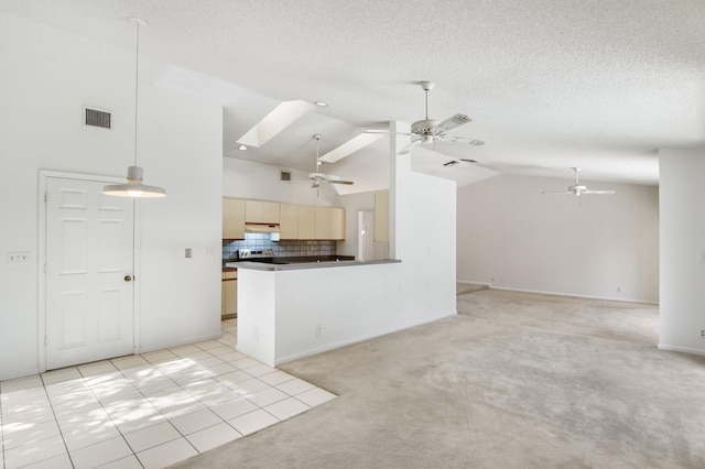 kitchen with high vaulted ceiling, a skylight, tasteful backsplash, light tile patterned flooring, and kitchen peninsula