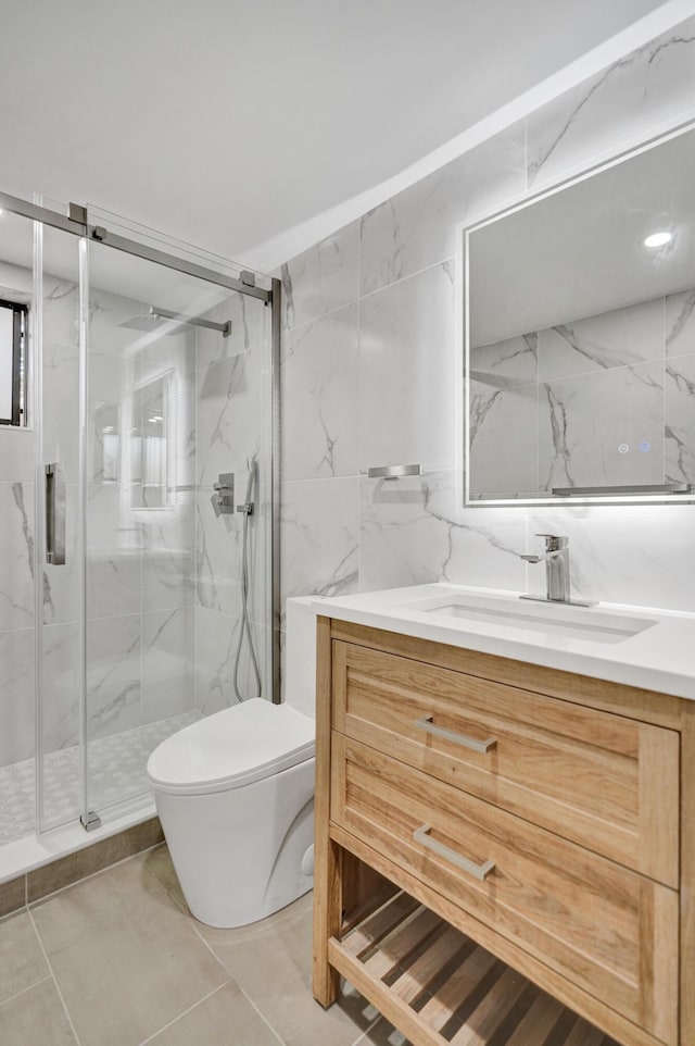 bathroom featuring toilet, a marble finish shower, vanity, and tile walls