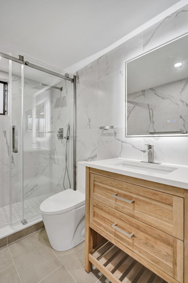 bathroom featuring walk in shower, vanity, tile walls, tile patterned flooring, and toilet