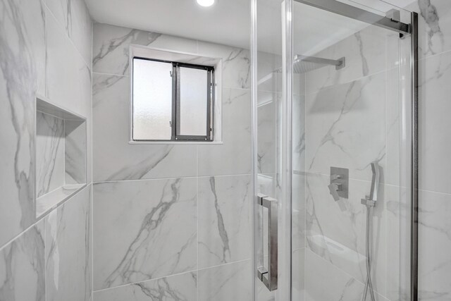 bathroom featuring a shower with door