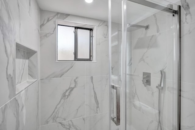 bathroom featuring a marble finish shower