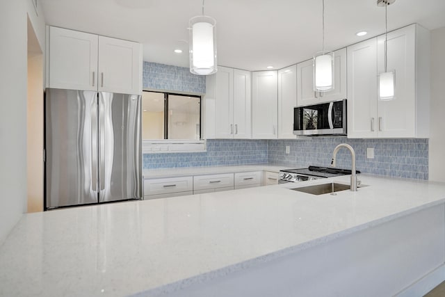 kitchen with appliances with stainless steel finishes, tasteful backsplash, light stone counters, white cabinetry, and recessed lighting
