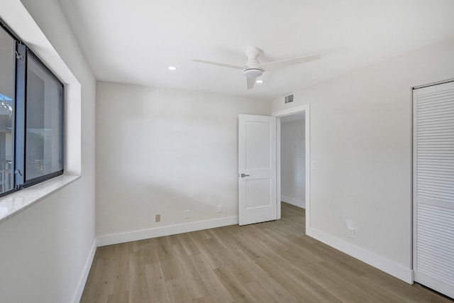 unfurnished bedroom with wood finished floors, baseboards, recessed lighting, a closet, and a ceiling fan