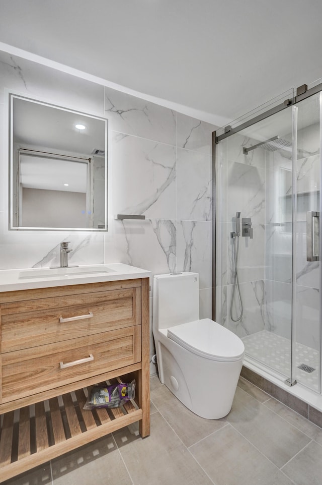 bathroom with tile patterned flooring, an enclosed shower, toilet, vanity, and tile walls