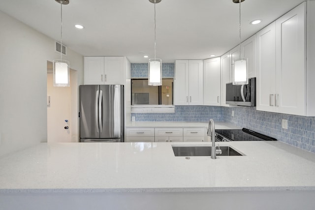 kitchen featuring sink, appliances with stainless steel finishes, white cabinetry, hanging light fixtures, and tasteful backsplash