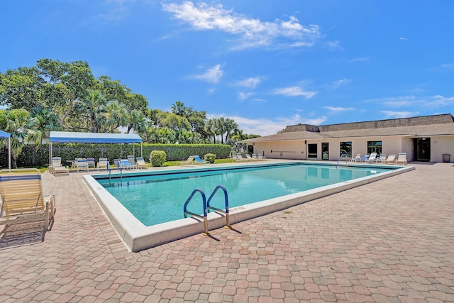 community pool featuring a patio and fence