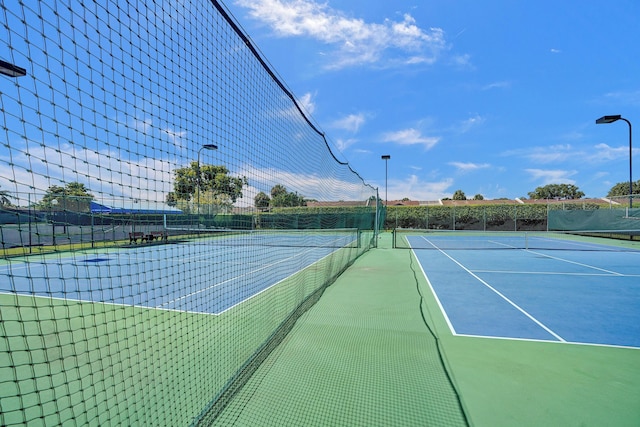 view of tennis court featuring fence