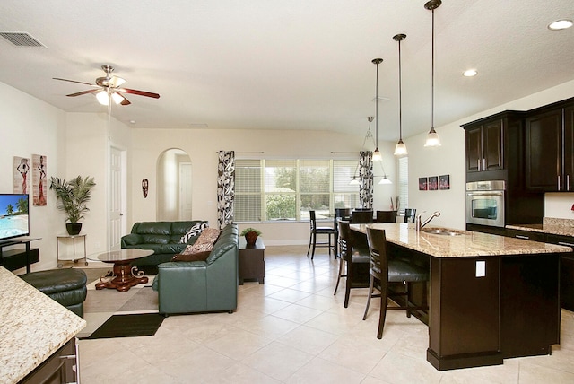 living room with light tile patterned floors, ceiling fan, and sink