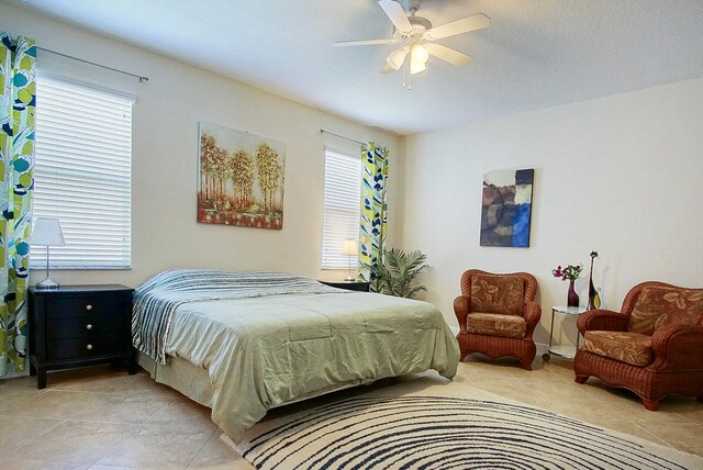 bedroom with light tile patterned floors, multiple windows, and ceiling fan