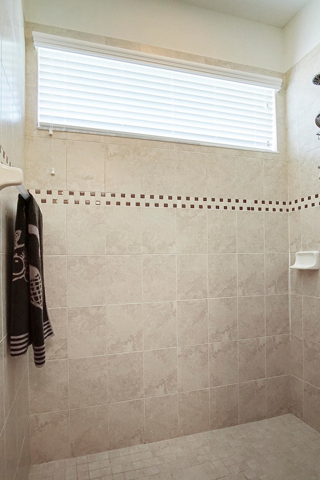 bathroom featuring a tile shower and a wealth of natural light