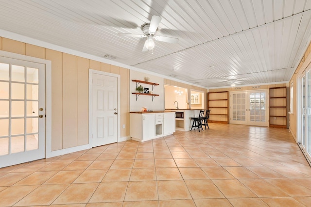 interior space featuring ceiling fan, light tile patterned floors, sink, and built in shelves