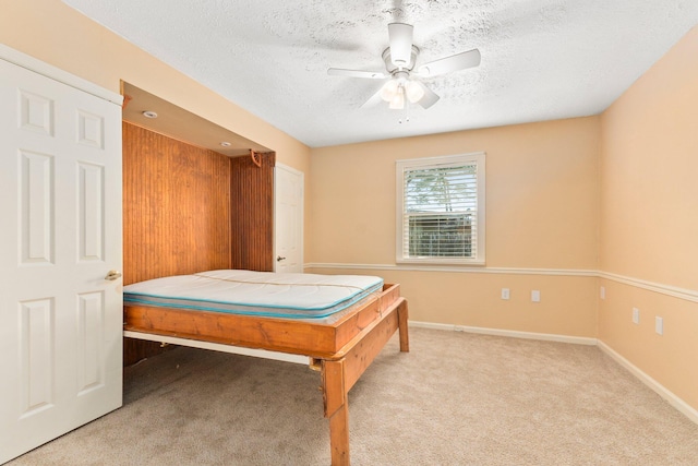 carpeted bedroom featuring a textured ceiling and ceiling fan