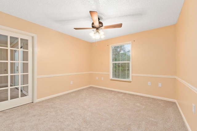 carpeted spare room with ceiling fan and a textured ceiling