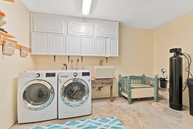 washroom with cabinets, washing machine and dryer, sink, and a textured ceiling