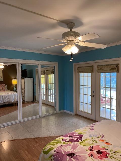 unfurnished bedroom featuring access to outside, ceiling fan, french doors, and light hardwood / wood-style flooring