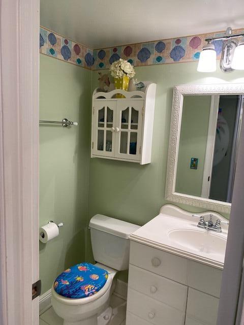 bathroom featuring tile patterned flooring, vanity, and toilet