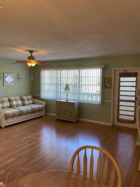 unfurnished living room with ceiling fan, wood-type flooring, and a textured ceiling