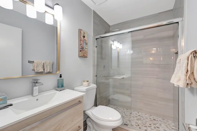 bathroom with vanity, a shower with shower door, and toilet