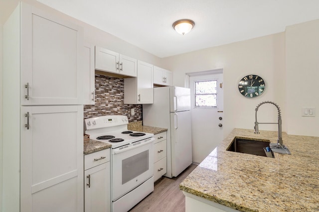 kitchen with white cabinetry, sink, light stone countertops, light hardwood / wood-style flooring, and white appliances