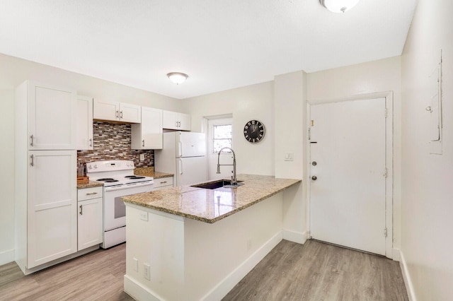 kitchen featuring white cabinetry, sink, light hardwood / wood-style flooring, kitchen peninsula, and white appliances