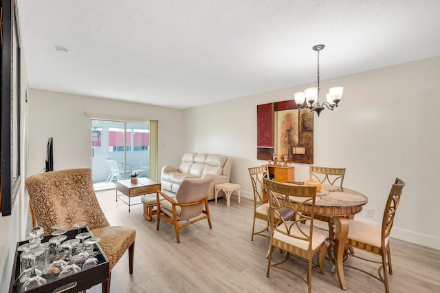 dining room with light hardwood / wood-style floors and an inviting chandelier