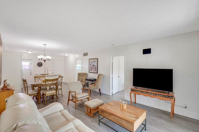 living room featuring hardwood / wood-style floors, a chandelier, and sink