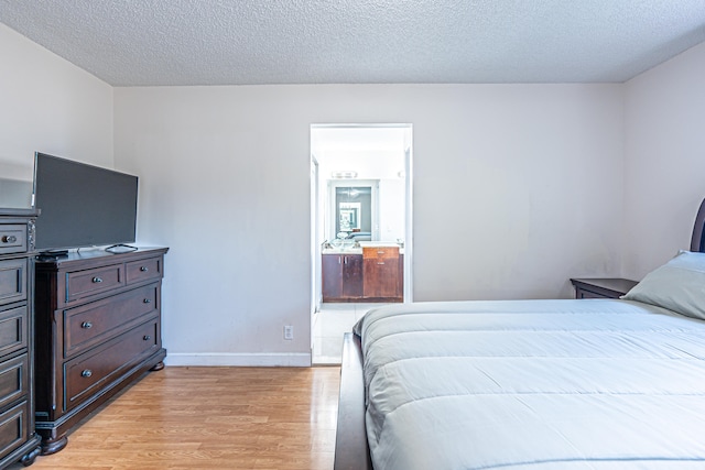 bedroom with light hardwood / wood-style floors and a textured ceiling