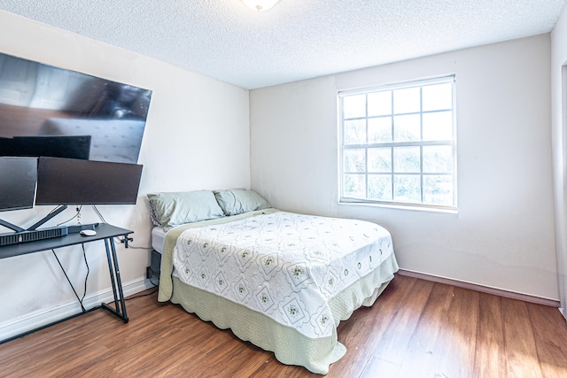 bedroom featuring dark hardwood / wood-style floors and a textured ceiling