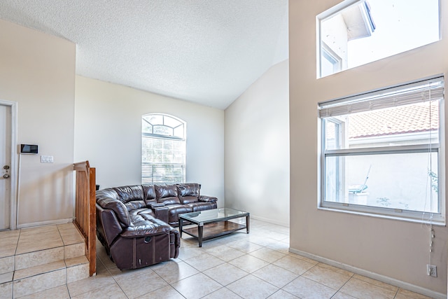 living room featuring a textured ceiling, high vaulted ceiling, and light tile patterned flooring