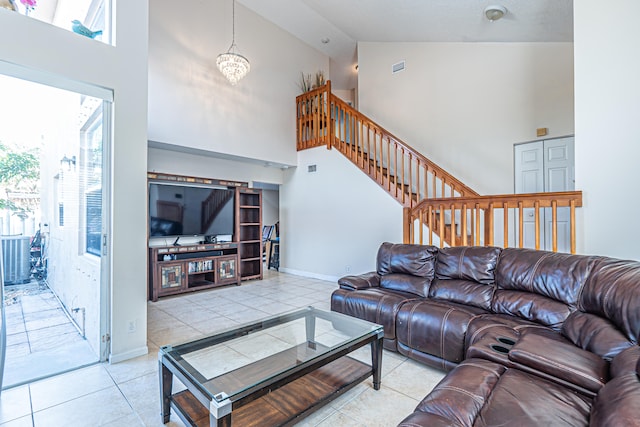 tiled living room featuring plenty of natural light, high vaulted ceiling, and a chandelier