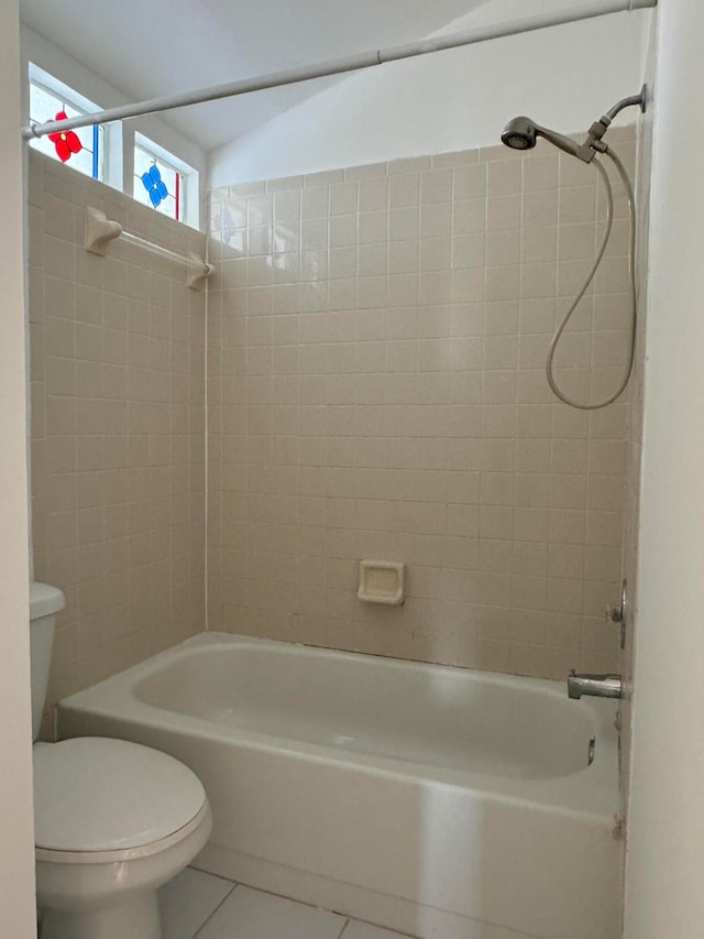 bathroom with toilet, tile patterned floors, and tiled shower / bath