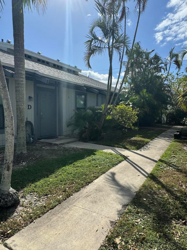 view of side of home with a yard