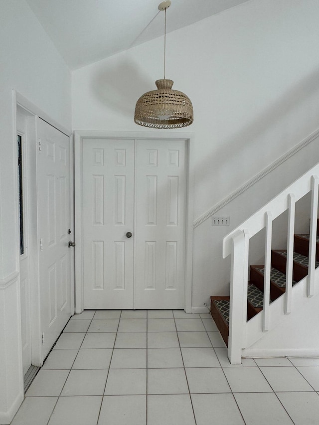 interior space featuring light tile patterned flooring and vaulted ceiling